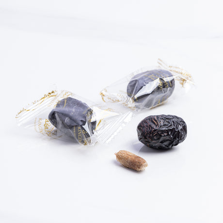 Ajwa Al Madina Dates wrapped in packaging, showing dark, glossy medjool dates from Kingdom Dates UAE.