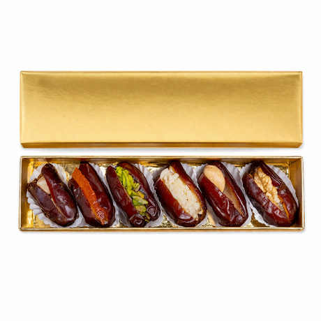 Golden mixed stuffed dates with nuts from Kingdom Dates UAE, premium dates in a gift box, featuring rich filling and elegant presentation.