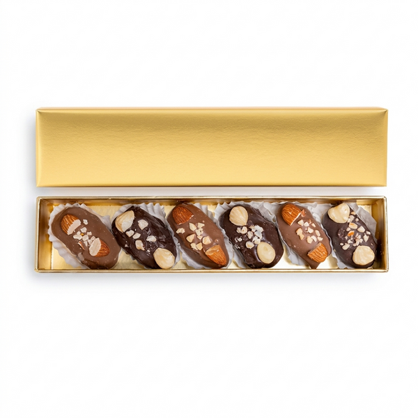 Golden mixed covered chocolate dates with nuts in a gift box, showcasing glossy chocolates and nut-filled dates from kingdomdatesuae.