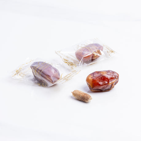 Wrapped Khalas dates from Kingdom Dates UAE, showcasing glossy, plump dates with a natural, caramel-brown appearance.