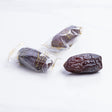 Majdoul jumbo dates from Kingdom Dates UAE, large, glossy, and wrapped in clear plastic, showcasing their rich, caramel color.