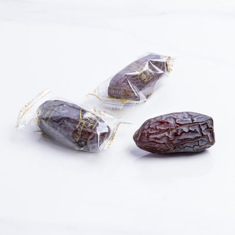 Majdoul jumbo dates from Kingdom Dates UAE, large, glossy, and wrapped in clear plastic, showcasing their rich, caramel color.