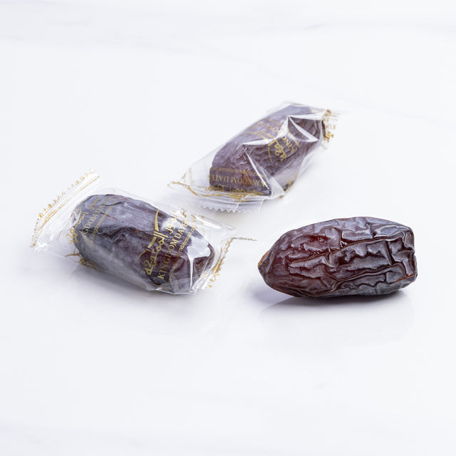 Majdoul jumbo dates from Kingdom Dates UAE, large, glossy, and wrapped in clear plastic, showcasing their rich, caramel color.