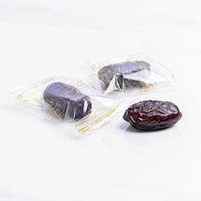 Wrapped Safawi Al Madina dates from Kingdom Dates UAE, showcasing plump, glossy, dark brown dates in a clear wrapping.