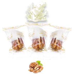 Wrapped vanilla chocolate dates stuffed with nuts and dried fruits from Kingdom Dates UAE, showing white chocolate coating and walnut filling.